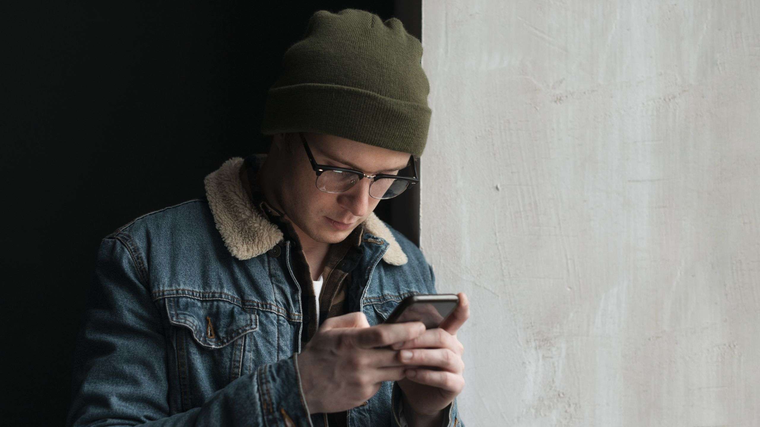 uomo in jeans usa smartphone