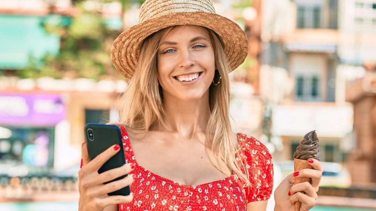 donna con smartphone in mano e gelato
